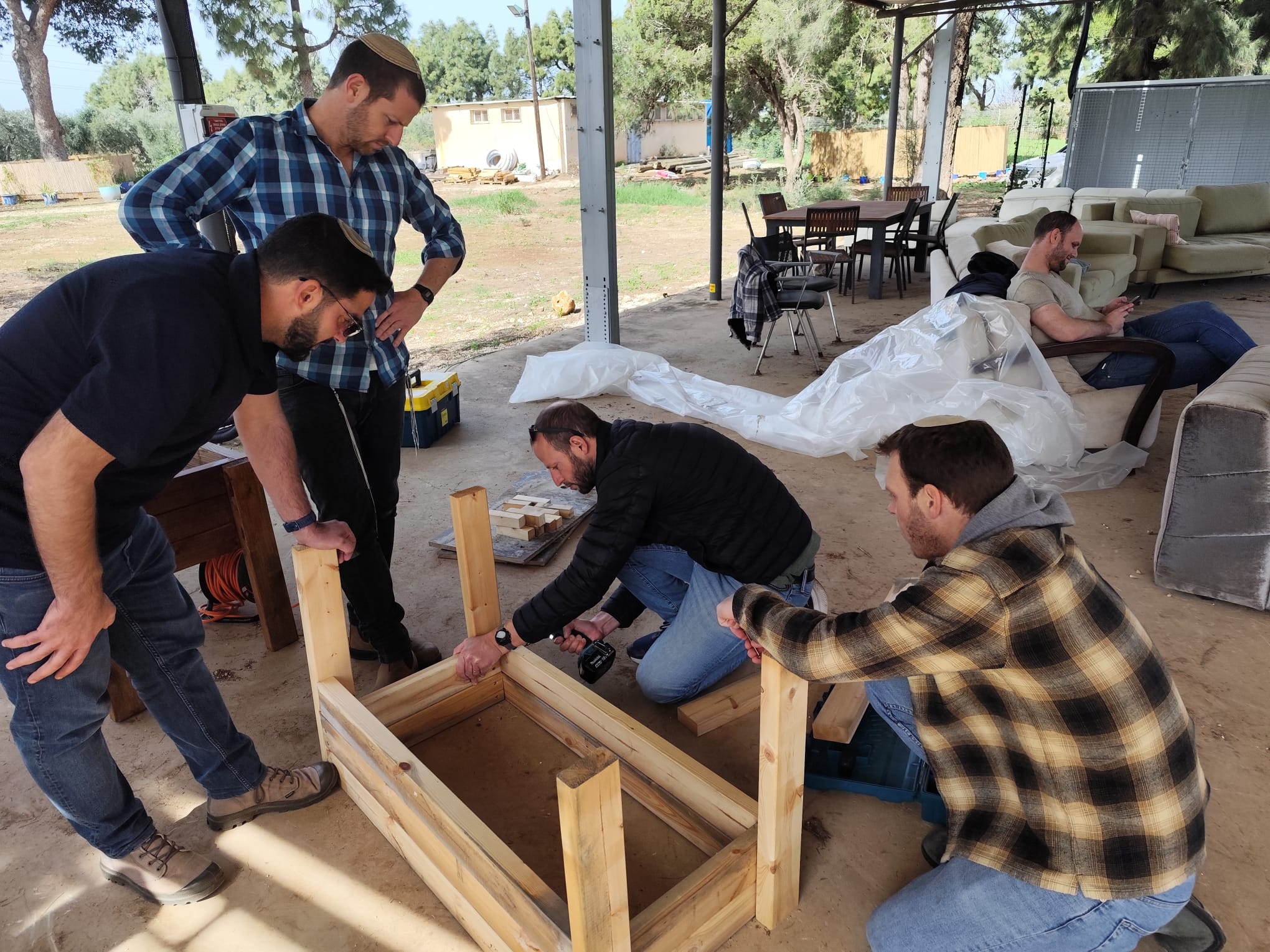Close-up of participants building a wooden frame